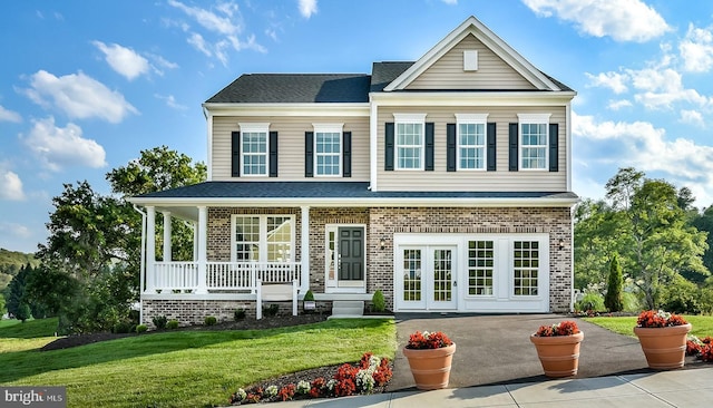 view of front of property with a porch, a front yard, and french doors