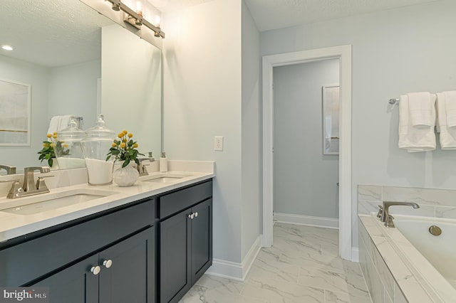 bathroom with a textured ceiling, tile floors, a relaxing tiled bath, and double sink vanity