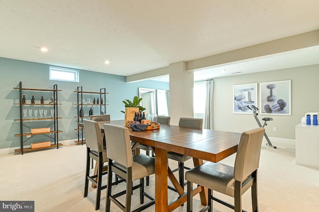 carpeted dining space featuring a textured ceiling