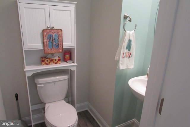 bathroom featuring toilet, sink, and hardwood / wood-style floors