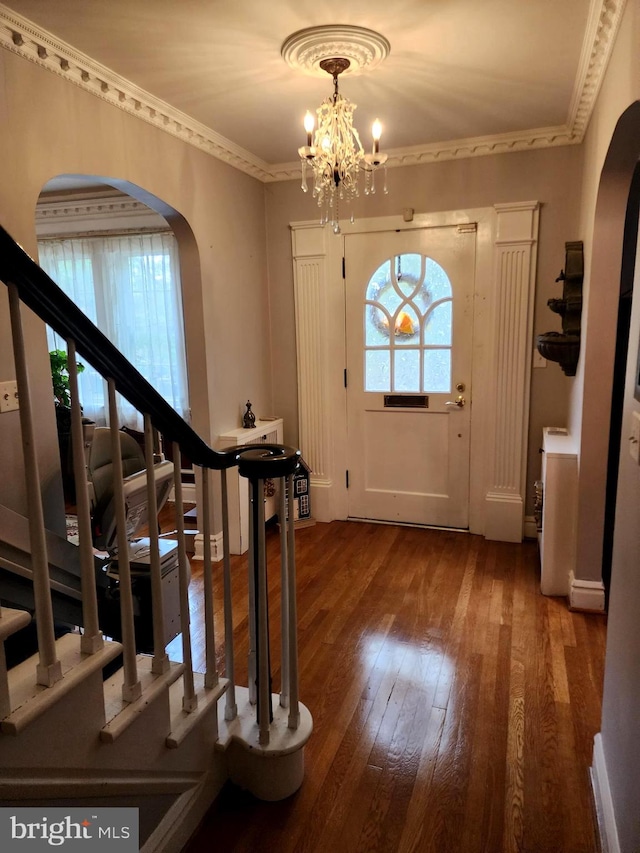 entryway featuring crown molding, dark hardwood / wood-style floors, and a notable chandelier