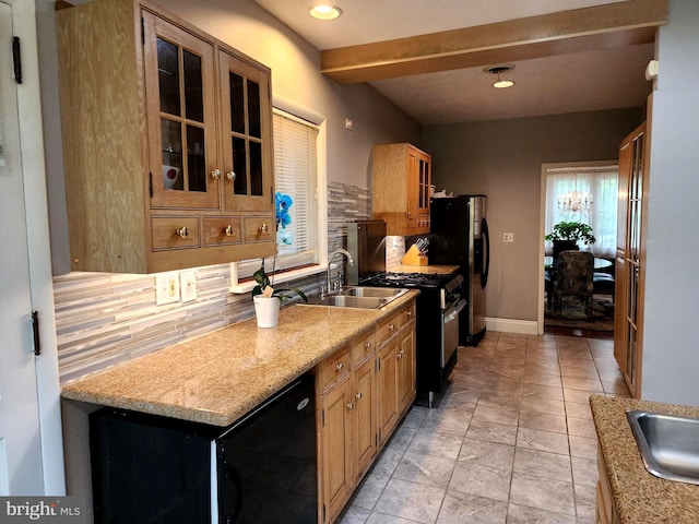 kitchen with range with gas stovetop, light tile flooring, tasteful backsplash, light stone counters, and sink