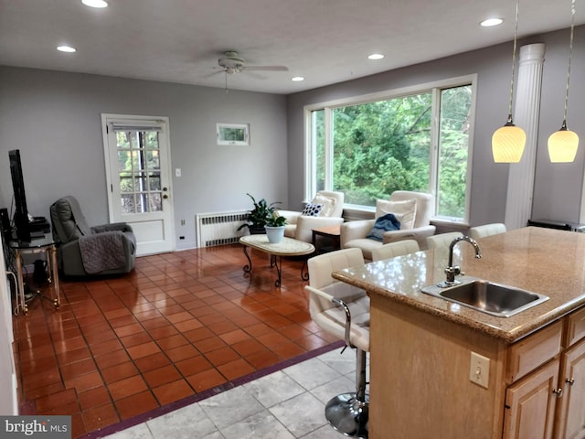 living room featuring sink, ceiling fan, radiator heating unit, and light tile floors