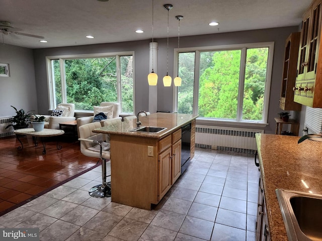 kitchen with a healthy amount of sunlight, sink, a center island, and light tile floors