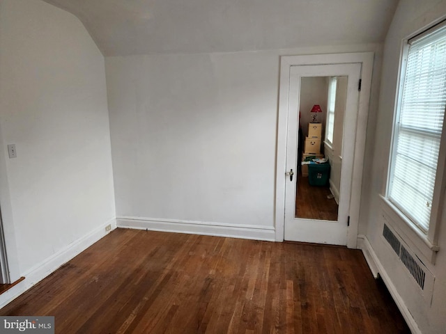 unfurnished room with dark hardwood / wood-style flooring, radiator heating unit, and lofted ceiling