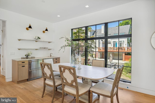 dining space with a healthy amount of sunlight and light hardwood / wood-style floors