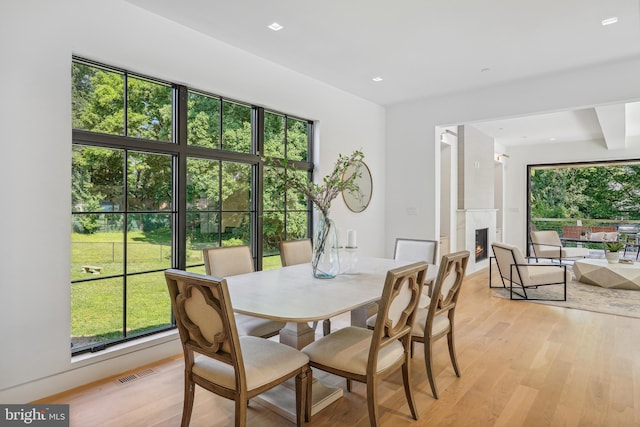 dining space featuring light hardwood / wood-style floors and beam ceiling