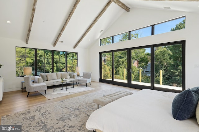 bedroom featuring french doors, multiple windows, high vaulted ceiling, and light hardwood / wood-style flooring