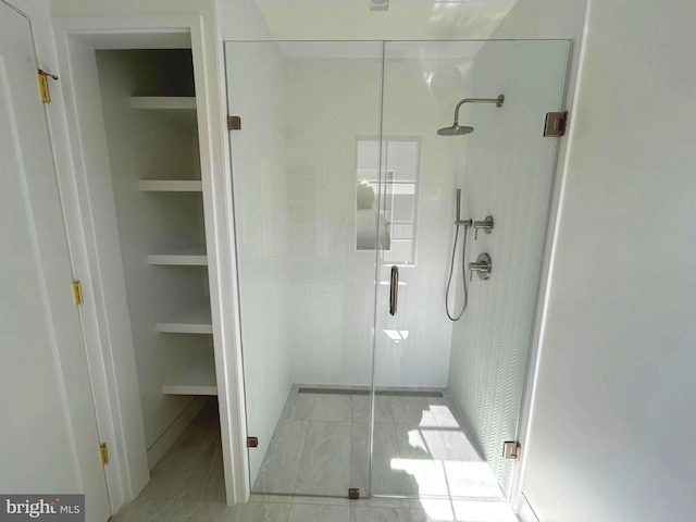 bathroom with built in shelves and an enclosed shower