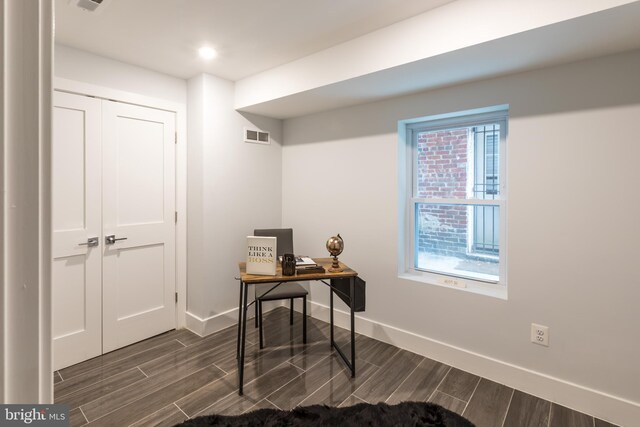 office with dark wood-type flooring and a healthy amount of sunlight