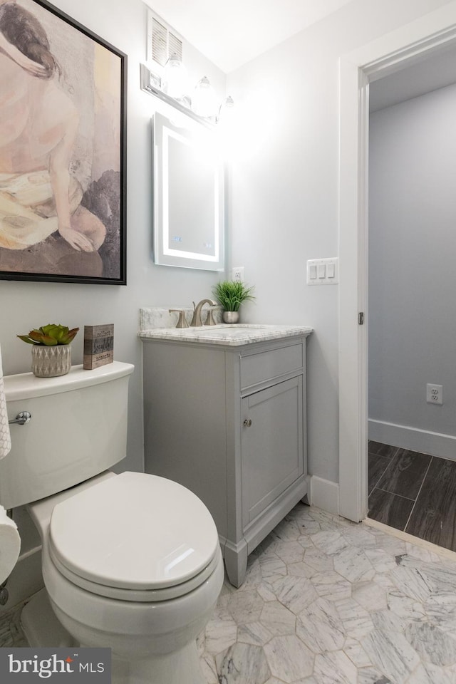 bathroom featuring hardwood / wood-style flooring, toilet, and vanity