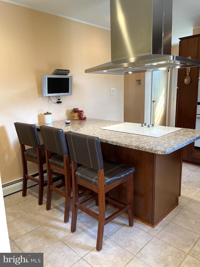 kitchen featuring a breakfast bar area, kitchen peninsula, light tile floors, and island range hood