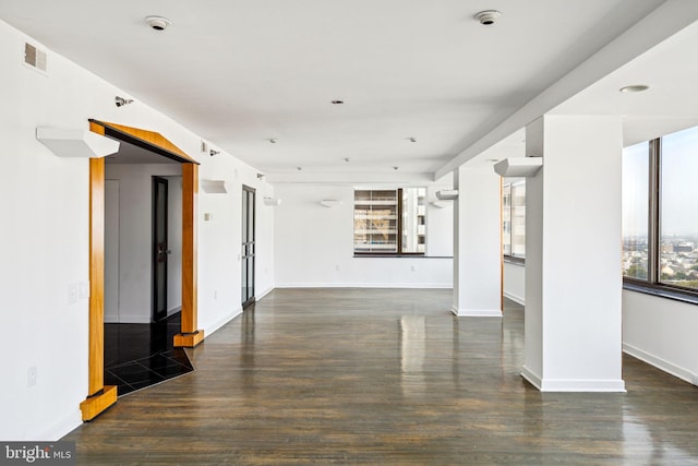 interior space with plenty of natural light and dark hardwood / wood-style flooring