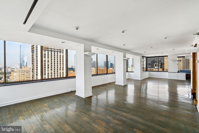 unfurnished living room featuring dark hardwood / wood-style flooring and a wealth of natural light