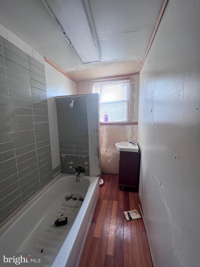 bathroom with vanity, tiled shower / bath combo, and wood-type flooring