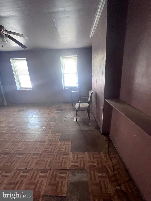 bonus room with dark parquet floors and ceiling fan