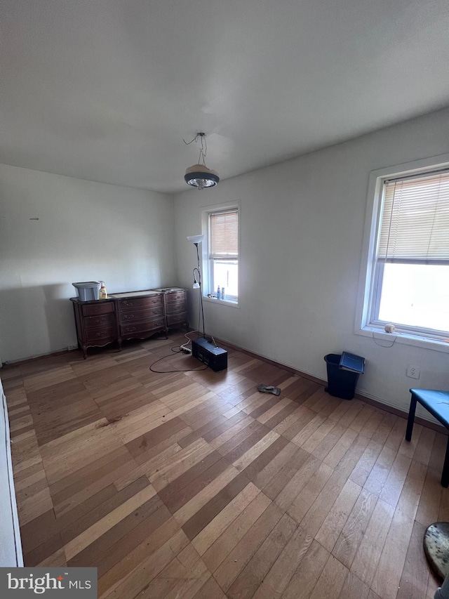 unfurnished bedroom featuring hardwood / wood-style floors and multiple windows