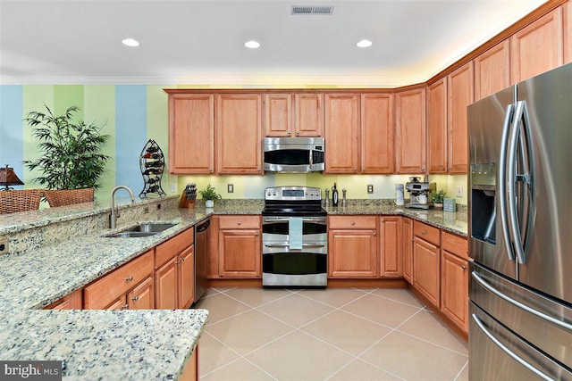 kitchen with sink, light tile floors, stainless steel appliances, and light stone countertops