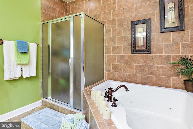 bathroom with tile flooring, shower with separate bathtub, and tile walls