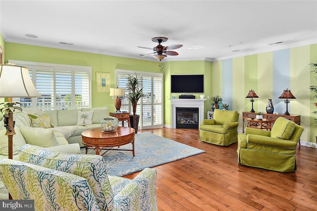 living room featuring ceiling fan, crown molding, and wood-type flooring