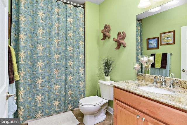 bathroom featuring toilet, vanity with extensive cabinet space, and tile floors