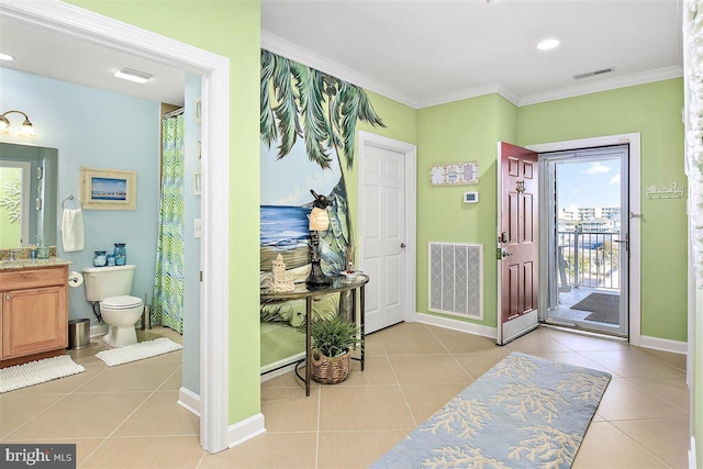 entrance foyer featuring light tile floors and crown molding