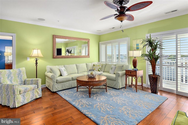 living room featuring dark hardwood / wood-style floors, ceiling fan, and ornamental molding