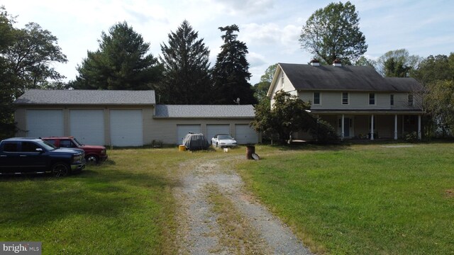 view of front of property featuring a front lawn, a porch, and a garage