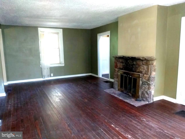 unfurnished living room featuring a fireplace, a textured ceiling, and hardwood / wood-style flooring