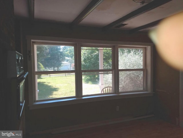 interior space featuring beamed ceiling and a healthy amount of sunlight