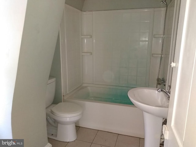 bathroom featuring tile patterned floors, tiled shower / bath combo, and toilet