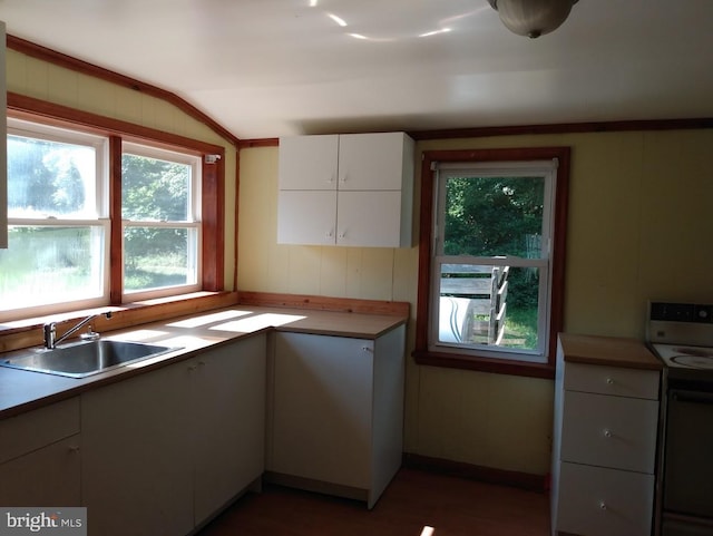 kitchen featuring white cabinets, lofted ceiling, white electric range, and sink