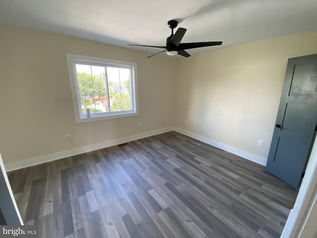 empty room featuring ceiling fan and dark wood-type flooring