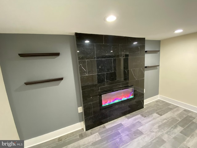 room details featuring hardwood / wood-style floors and a tiled fireplace