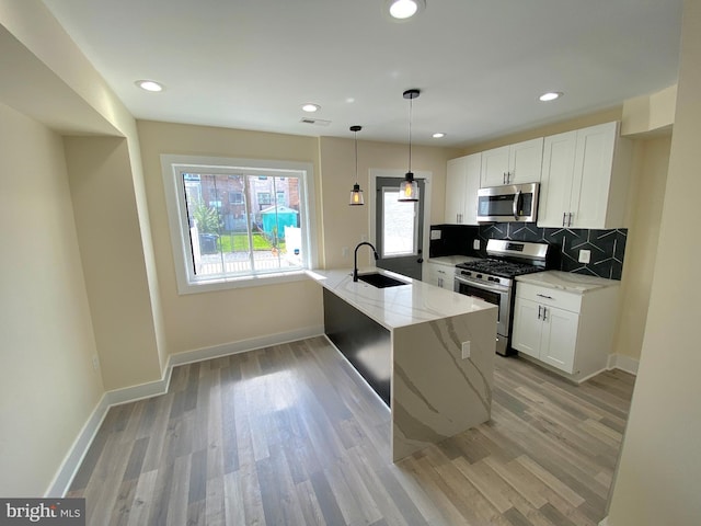 kitchen featuring tasteful backsplash, sink, white cabinets, and stainless steel appliances