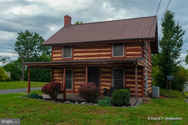 log cabin with a front lawn and covered porch