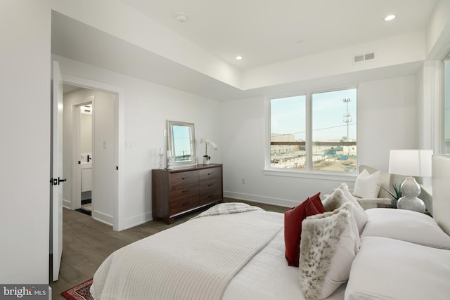 bedroom featuring multiple windows and dark wood-type flooring