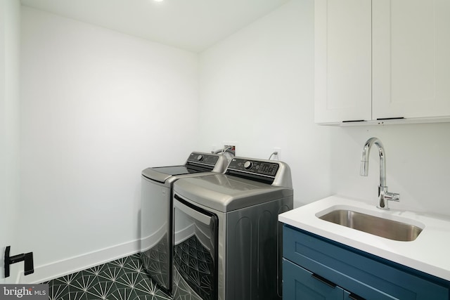 laundry room with washer hookup, dark tile floors, sink, cabinets, and washing machine and dryer