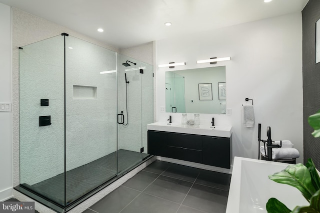 bathroom with a shower with door, tile floors, oversized vanity, and dual sinks