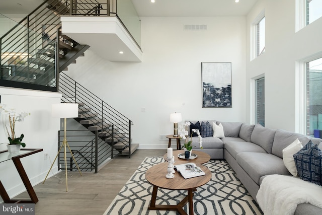 living room with light hardwood / wood-style floors and a high ceiling