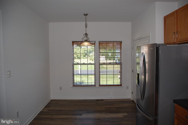 kitchen featuring plenty of natural light, hanging light fixtures, stainless steel fridge, and dark hardwood / wood-style flooring