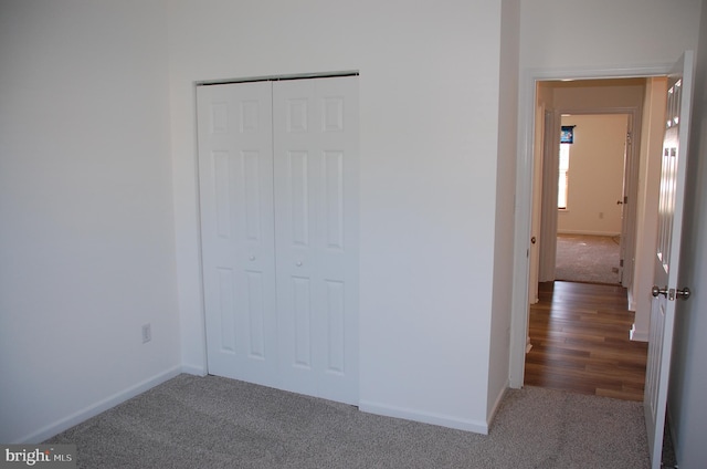 unfurnished bedroom with a closet and dark wood-type flooring