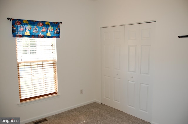 unfurnished bedroom with a closet, carpet floors, and multiple windows