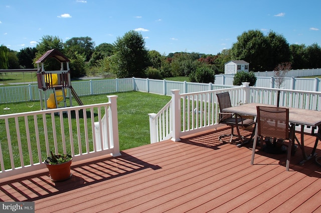 wooden deck with a playground and a yard