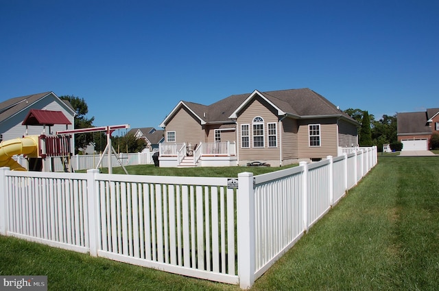 view of front of property with a wooden deck, a playground, and a front yard