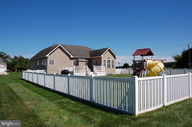 exterior space with a deck, a front yard, and a playground