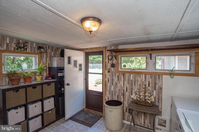 bathroom featuring wooden walls, tile flooring, and washing machine and dryer