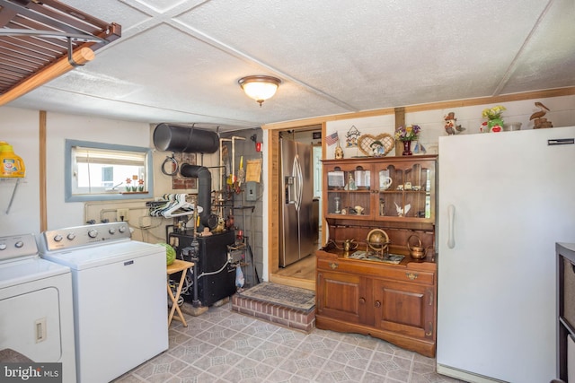 clothes washing area with washing machine and clothes dryer and light tile floors