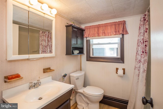 bathroom with vanity, baseboard heating, and toilet