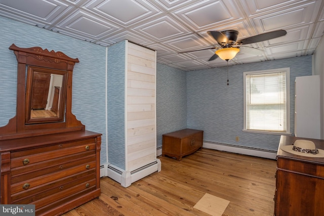 interior space featuring a baseboard radiator, ceiling fan, and light wood-type flooring